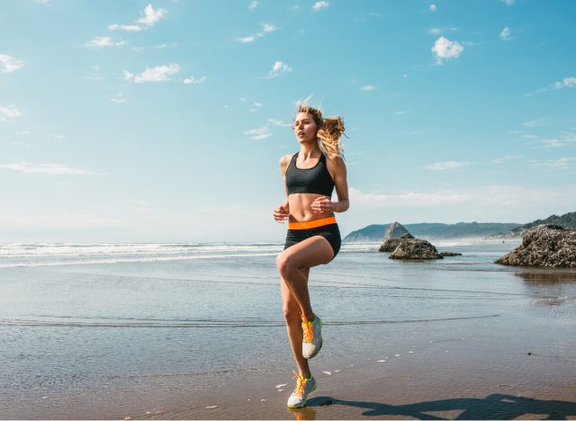 Woman doing HIIT workout on the beach, concept of exercise to melt belly fat